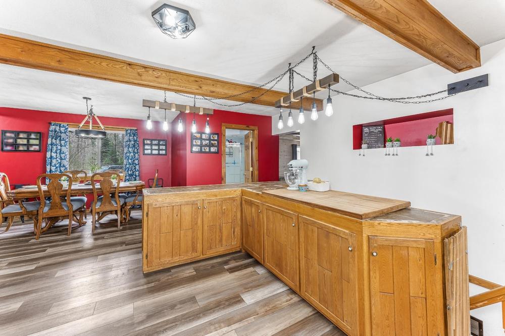 Open concept counter connecting the kitchen to the dining room, red walls visible in background